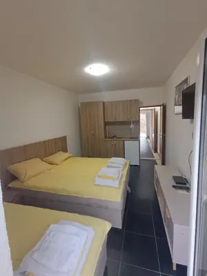 a small room with two beds and a kitchen at Una Apartments in Budva