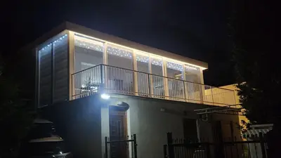 a house with a balcony with lights on it at night at Sunset Villa in Bar
