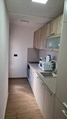 a kitchen with white appliances and wooden cabinets at Sunset Villa in Bar