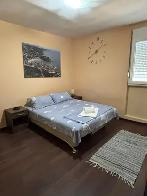 a bedroom with a bed and a clock on the wall at Apartman Sonib in Ulcinj