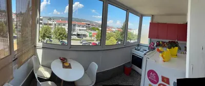 a kitchen with windows and a table and a counter at Apartman Sonib in Ulcinj