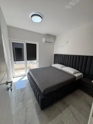 a bedroom with a large bed and two windows at Mona in Ulcinj