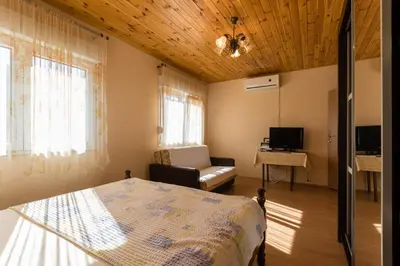 a bedroom with a bed and a couch in a room at Apartment Sjekloca in Virpazar