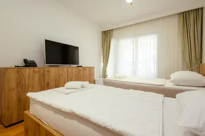 a hotel room with two beds and a flat screen tv at Hotel PIO in Ulcinj