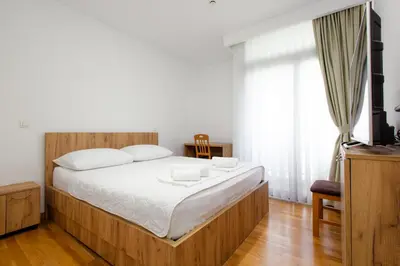 a bedroom with a large bed and a television at Hotel PIO in Ulcinj