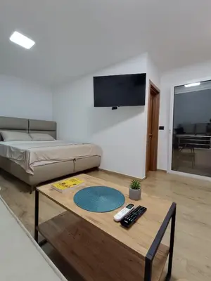 a living room with a coffee table and a bed at ApartmaniMD apartman 2 mirno utociste in Sutomore