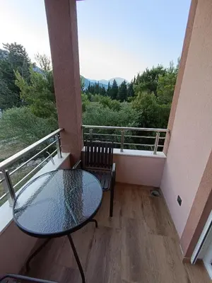 a balcony with a glass table and two chairs at ApartmaniMD apartman 2 mirno utociste in Sutomore