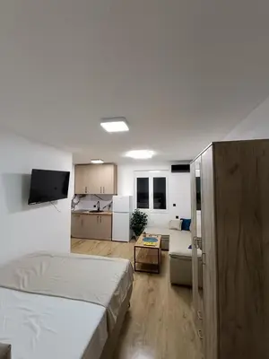a bedroom with a bed and a living room at ApartmaniMD apartman 2 mirno utociste in Sutomore