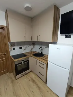 a kitchen with white cabinets and a white refrigerator at ApartmaniMD apartman 5 uzivanje na pravom mjestu in Sutomore