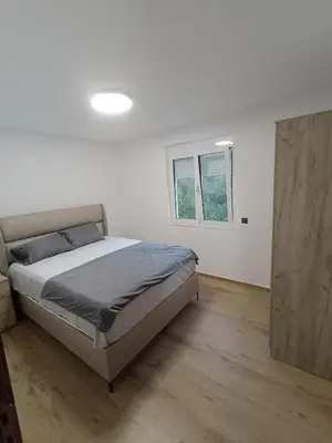 a white bedroom with a bed and a window at ApartmaniMD apartman 5 uzivanje na pravom mjestu in Sutomore