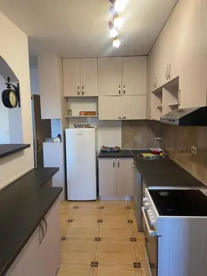 a kitchen with white cabinets and a white refrigerator at Apartman Anastasija in Kotor