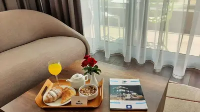 a tray of food and a glass of wine on a table at Perla Luxury in Ulcinj
