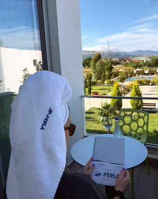 a person with a white towel on their head sitting at a table at Perla Luxury in Ulcinj