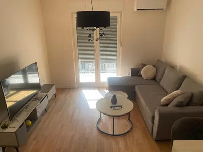 a living room with a couch and a flat screen tv at Alex 2210 in Podgorica