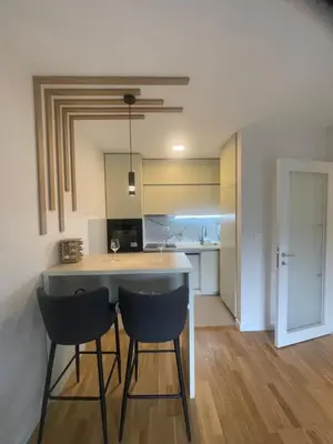 a kitchen with two chairs and a island in a room at Alex 2210 in Podgorica