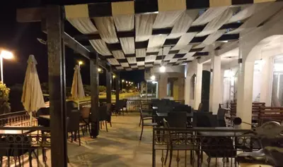 an empty restaurant with tables and chairs at night at Pansion Aksa in Ulcinj