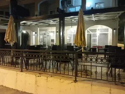 a restaurant with tables and chairs and umbrellas at Pansion Aksa in Ulcinj