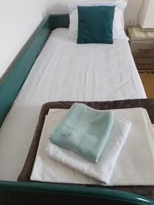 a bed with towels on top of it at Nada Apartman in Lastva
