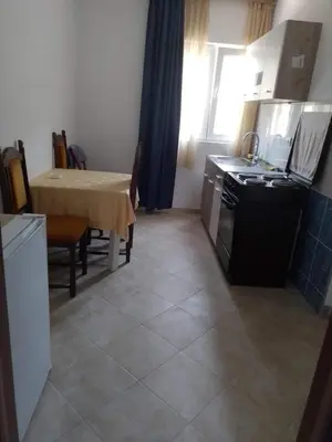 a kitchen and dining room with a table and a stove at Nada Apartman in Lastva