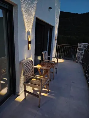 two chairs and a wooden table on a balcony at Maginja in Petrovac na Moru