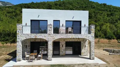 a stone house with a balcony on top of it at Maginja in Petrovac na Moru