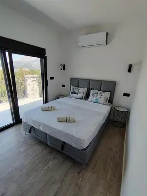 a large bed in a room with a large window at Maginja in Petrovac na Moru