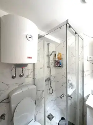 a bathroom with a toilet and a glass shower at Nina apartman in Budva