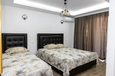 a bedroom with two beds and a chandelier at Apartments Ceka in Ulcinj