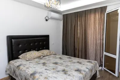 a bedroom with a bed with a black headboard and a window at Apartments Ceka in Ulcinj