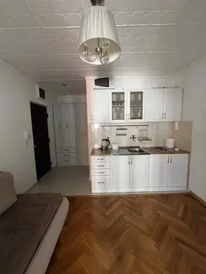 an empty kitchen with white cabinets and a ceiling at Marko's place in Budva