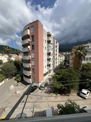 a tall pink building in a city with buildings at Marko's place in Budva