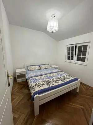 a bedroom with a bed and a chandelier at Marko's place in Budva