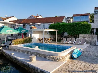 a swimming pool in front of a house at Vila PETICA in Tivat