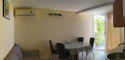 a dining room with a table and chairs and a window at UGS Apartment in Sutomore