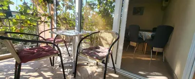 a glass table and chairs on a balcony with a window at UGS Apartment in Sutomore