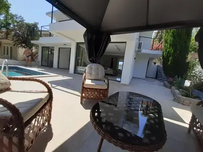 a patio with a table and chairs and a house at Villa vista mare in Zagrađe