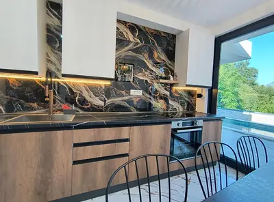 a kitchen with a sink and a table with chairs at Villa vista mare in Zagrađe