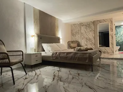a bedroom with a bed with marble floors and a chair at Villa vista mare in Zagrađe