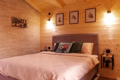 a bedroom with a bed in a wooden wall at Rural stay Miranovic in Balabani