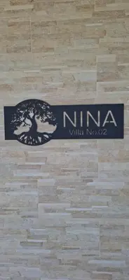 a nima logo on the wall of a room at Rural stay Miranovic in Balabani