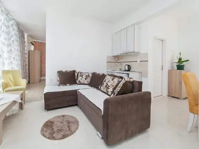 a living room with a brown couch and a kitchen at Villa INA in Kaluđerac