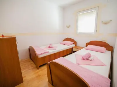 a room with two beds with pink sheets and a window at Villa INA in Kaluđerac