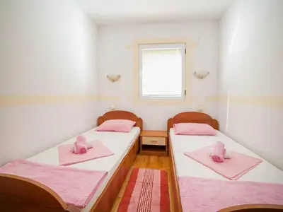 two beds in a room with pink towels on them at Villa INA in Kaluđerac