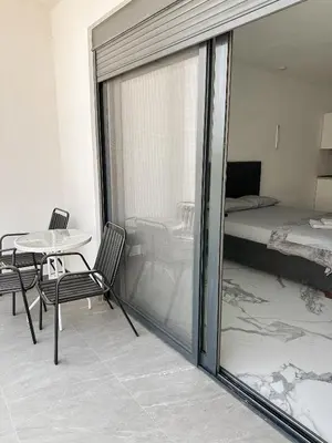 a balcony with a table and chairs and a bed at Alfredo in Ulcinj