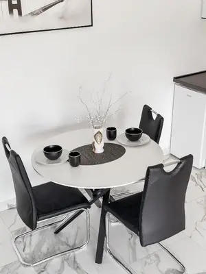 a white table with black chairs and a table with two cups at Alfredo in Ulcinj