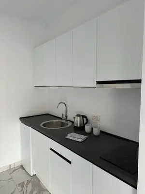 a white kitchen with a sink and white cabinets at Alfredo in Ulcinj