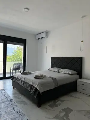 a bedroom with a large bed and a large window at Alfredo in Ulcinj