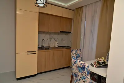 a kitchen with a sink and a table with a chair at Stars Five Apartments in Ulcinj