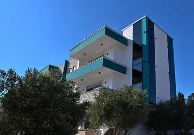 a tall building with trees in front of it at Stars Five Stay in Ulcinj