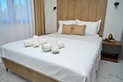 a bedroom with a large white bed with towels on it at Stars Five Stay in Ulcinj